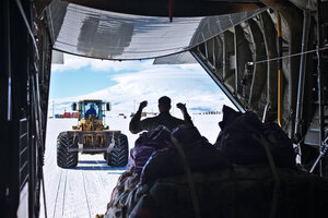 Cargo is pulled of the LC-130 with Mt. Erebus in the background